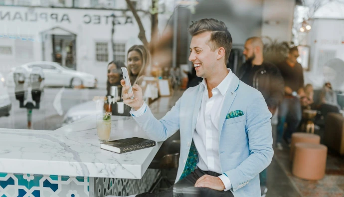 smiling man while holding smartphone